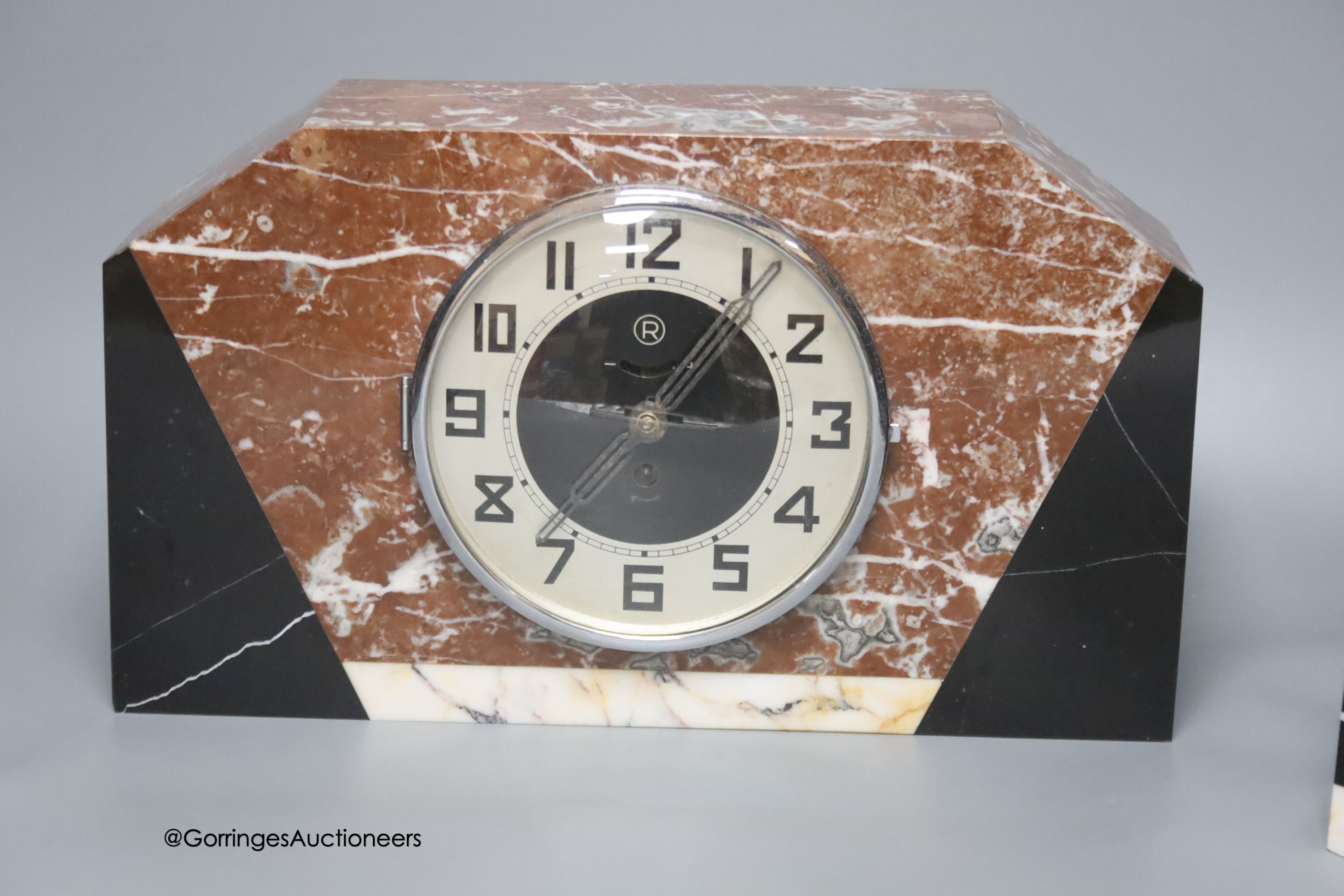 An Art Deco rouge marble clock garniture, length 36cm